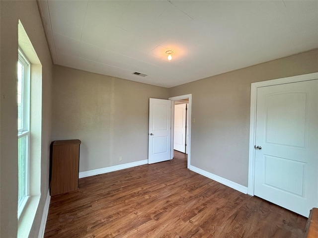 unfurnished bedroom featuring dark hardwood / wood-style flooring