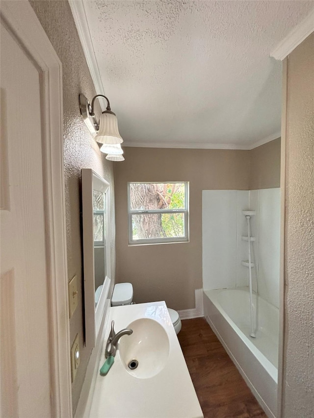 full bathroom with hardwood / wood-style floors, a textured ceiling, and ornamental molding