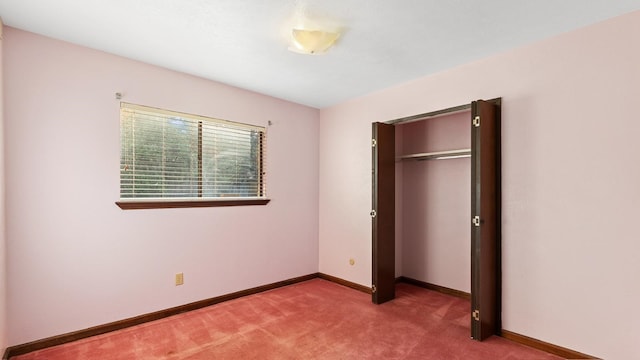 unfurnished bedroom with a closet and light colored carpet