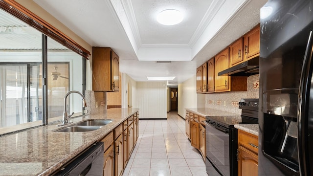 kitchen featuring light stone counters, a raised ceiling, crown molding, sink, and black appliances