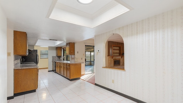 kitchen featuring black refrigerator, light tile patterned floors, and sink