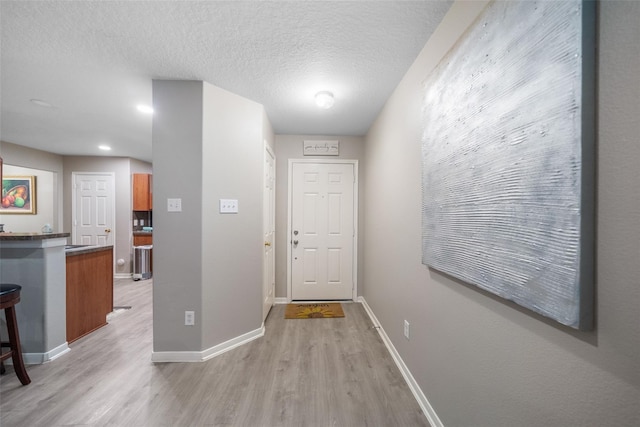 entryway featuring light hardwood / wood-style flooring and a textured ceiling