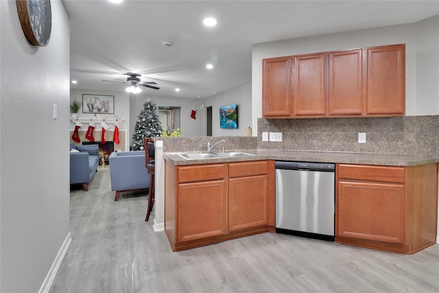 kitchen featuring ceiling fan, sink, tasteful backsplash, stainless steel dishwasher, and light hardwood / wood-style floors