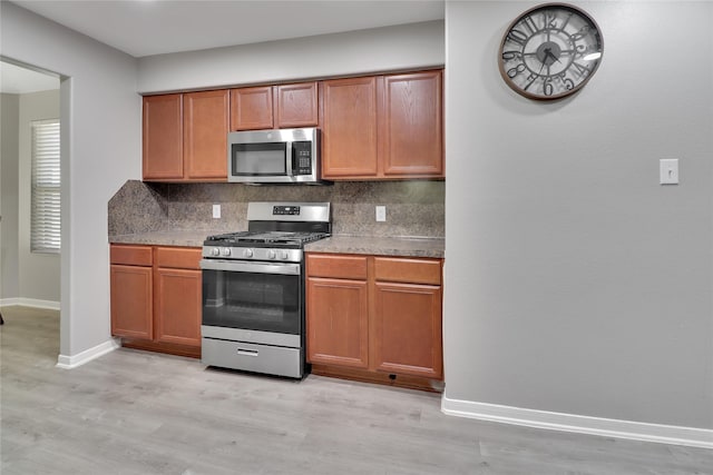 kitchen featuring backsplash, light hardwood / wood-style floors, and appliances with stainless steel finishes