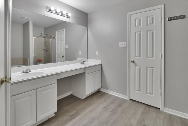 bathroom with plus walk in shower, vanity, and hardwood / wood-style flooring