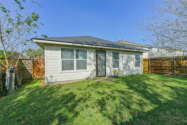 rear view of house featuring a yard