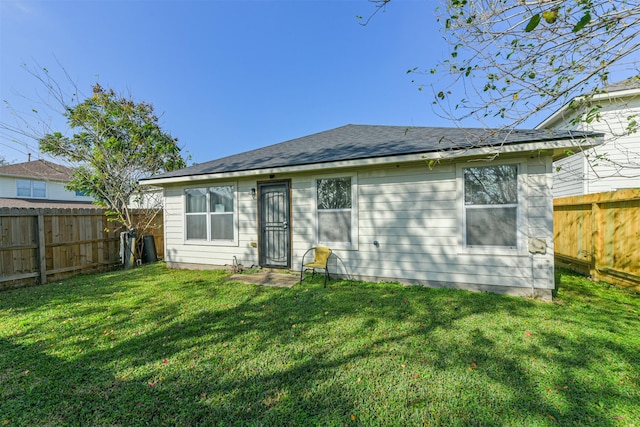 rear view of house featuring a yard