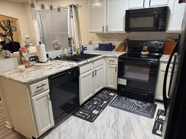 kitchen with black appliances, light stone counters, decorative backsplash, sink, and white cabinetry