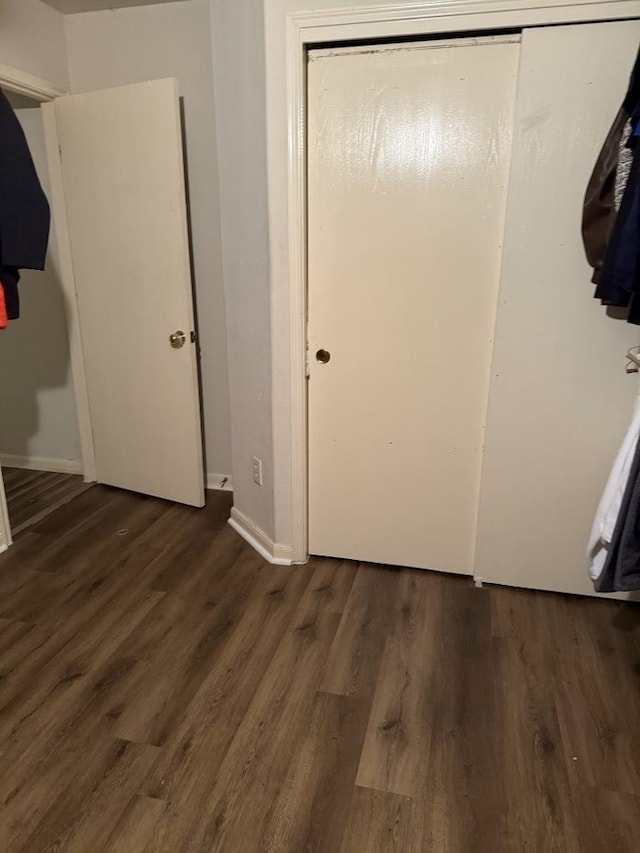 unfurnished bedroom with dark wood-type flooring and a closet