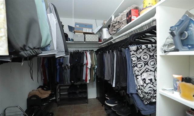 walk in closet with dark tile patterned flooring