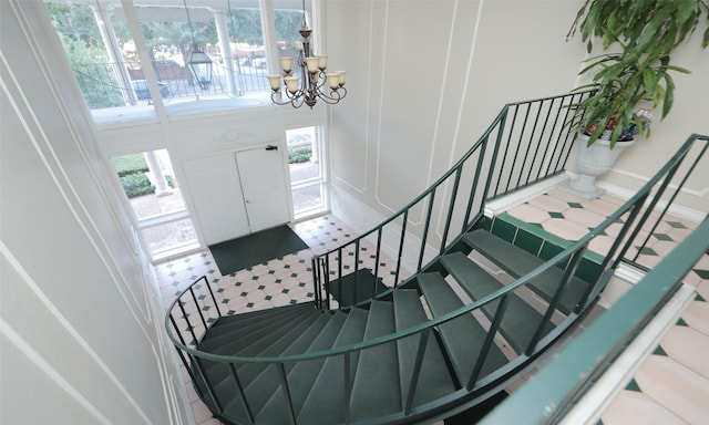 stairs featuring a chandelier and tile patterned flooring