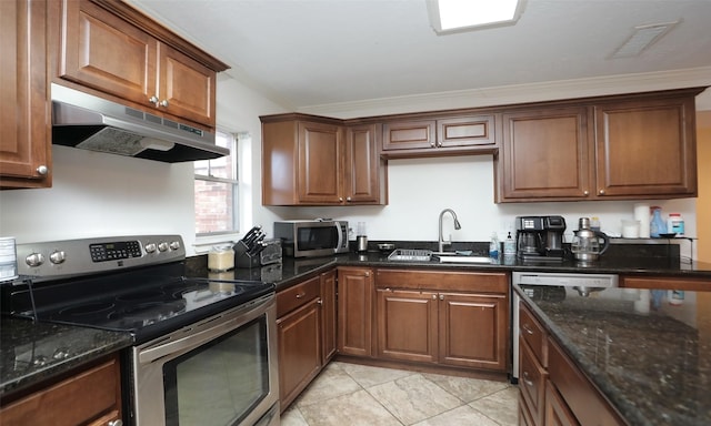 kitchen with dark stone counters, stainless steel appliances, ornamental molding, and sink