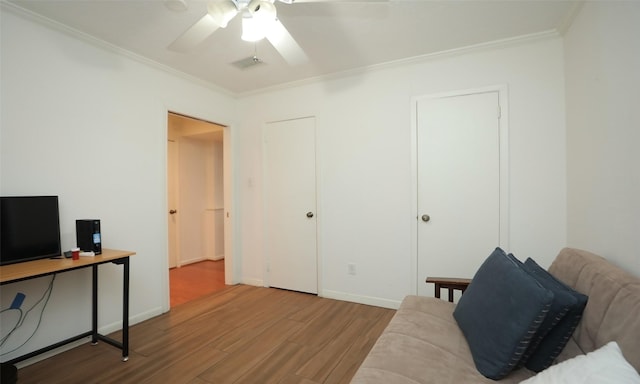 living area featuring crown molding, light hardwood / wood-style flooring, and ceiling fan