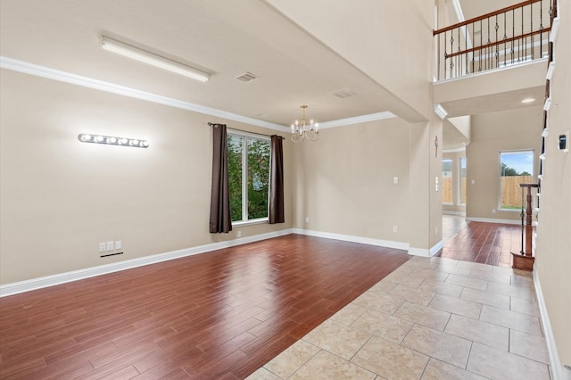 unfurnished room featuring crown molding and a chandelier