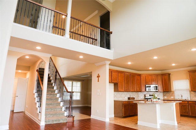 kitchen with a kitchen island, light hardwood / wood-style flooring, light stone counters, and appliances with stainless steel finishes