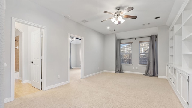 unfurnished bedroom with connected bathroom, light carpet, and ceiling fan