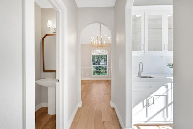 hallway featuring a chandelier, light hardwood / wood-style flooring, and sink