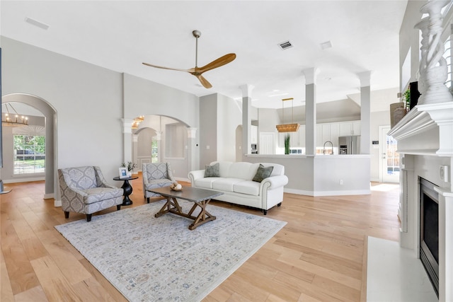 living room featuring light hardwood / wood-style flooring, ceiling fan, and sink