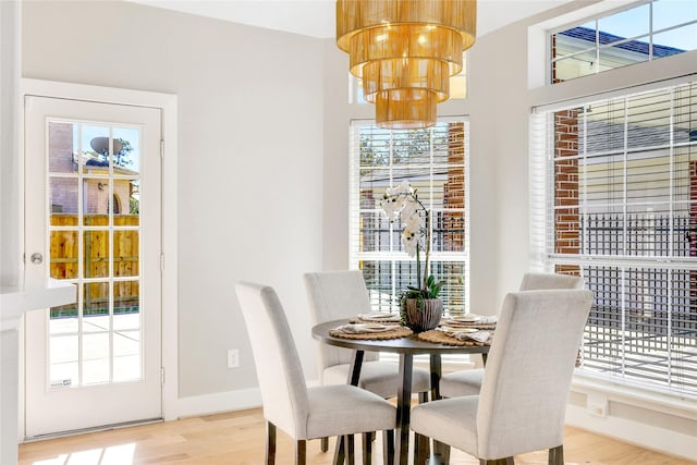 dining space with hardwood / wood-style floors and a chandelier