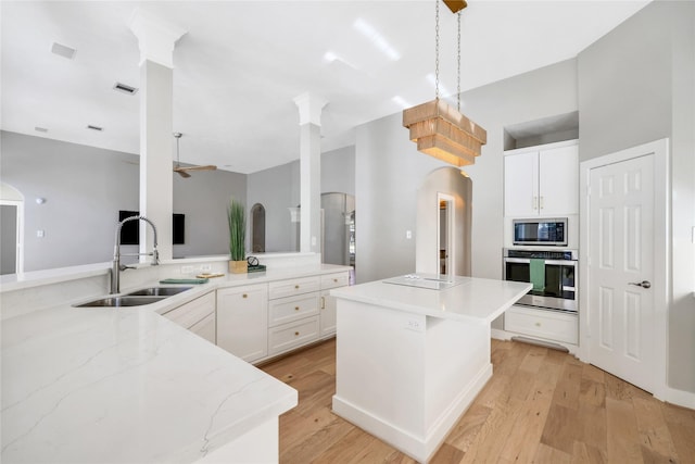 kitchen with white cabinetry, sink, a kitchen island, and appliances with stainless steel finishes