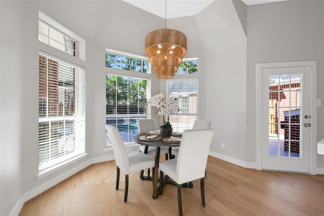 dining area featuring light hardwood / wood-style floors and high vaulted ceiling