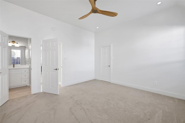 unfurnished bedroom with connected bathroom, ceiling fan, light colored carpet, and vaulted ceiling