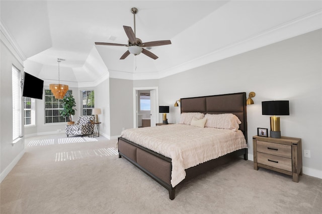 carpeted bedroom featuring a tray ceiling, crown molding, and ceiling fan with notable chandelier