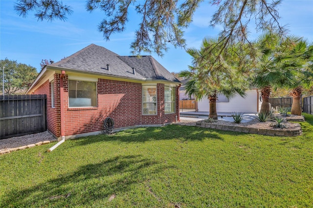 back of property with a lawn and a garage