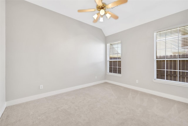 spare room with carpet floors, vaulted ceiling, a wealth of natural light, and ceiling fan