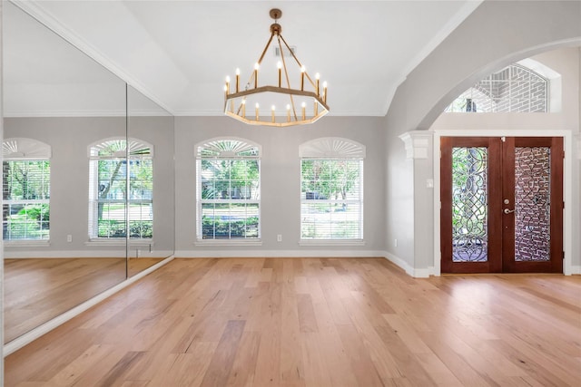 foyer entrance featuring a chandelier, french doors, light wood-type flooring, and a healthy amount of sunlight