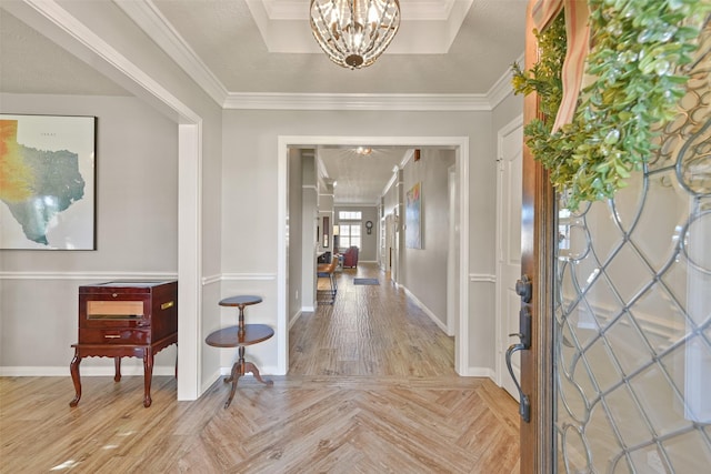 foyer with a textured ceiling, light parquet flooring, crown molding, and a notable chandelier