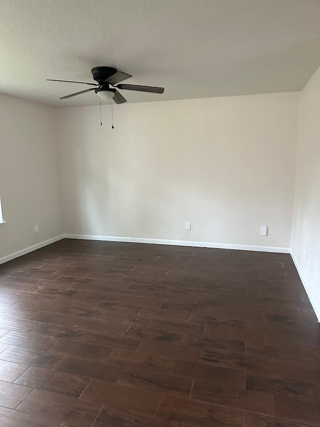 empty room with ceiling fan and dark hardwood / wood-style flooring