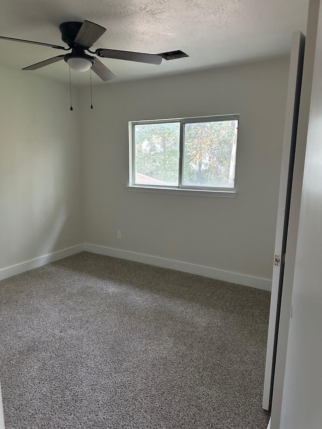 carpeted spare room featuring a textured ceiling and ceiling fan