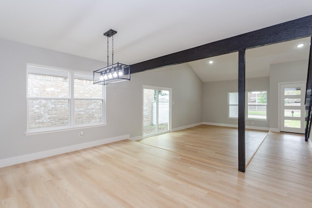 interior space with vaulted ceiling with beams, plenty of natural light, and light hardwood / wood-style flooring