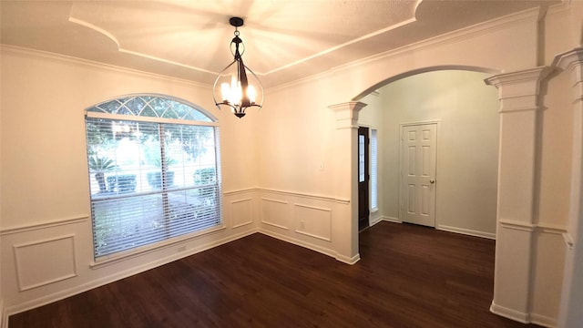 unfurnished dining area with ornate columns, an inviting chandelier, dark hardwood / wood-style floors, and ornamental molding