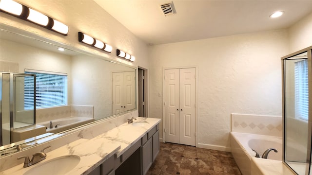 bathroom with vanity and a relaxing tiled tub