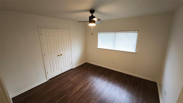 unfurnished bedroom featuring ceiling fan, a closet, and dark hardwood / wood-style floors