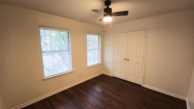 unfurnished bedroom featuring ceiling fan, a closet, and dark wood-type flooring