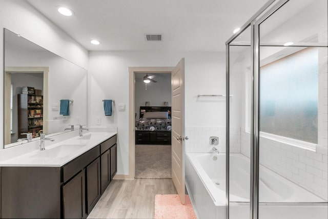 bathroom featuring vanity, separate shower and tub, plenty of natural light, and wood-type flooring