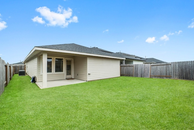 back of property with a yard, a patio, and central AC