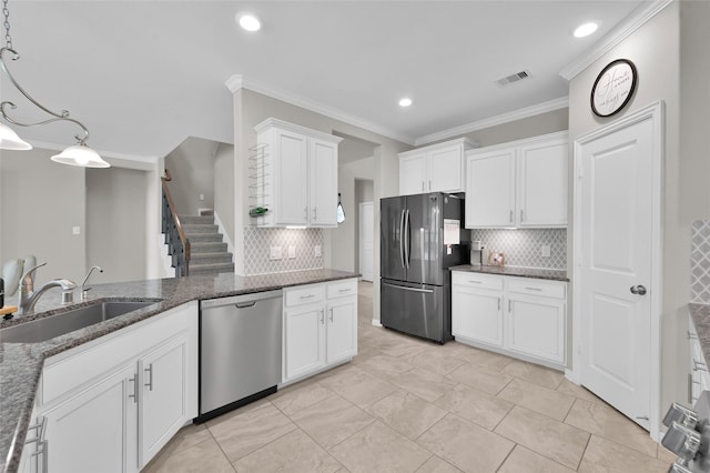 kitchen featuring pendant lighting, white cabinets, sink, ornamental molding, and appliances with stainless steel finishes