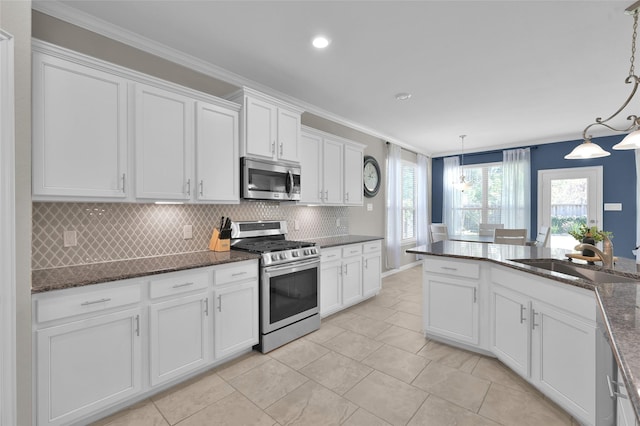 kitchen with decorative light fixtures, sink, white cabinetry, and stainless steel appliances