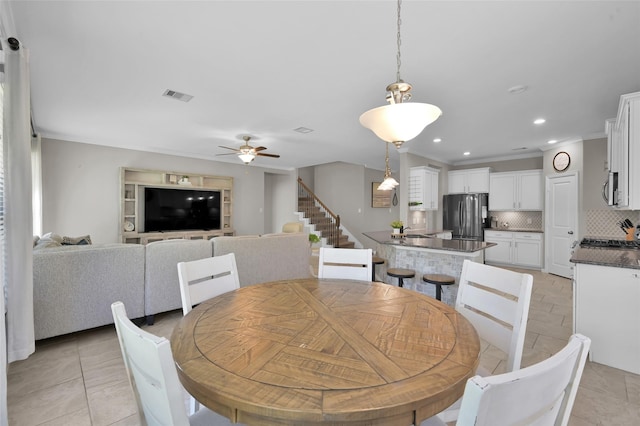 dining room featuring ceiling fan, ornamental molding, sink, and light tile patterned floors