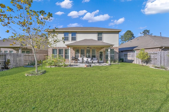 rear view of property with ceiling fan, a yard, a patio, and an outdoor hangout area