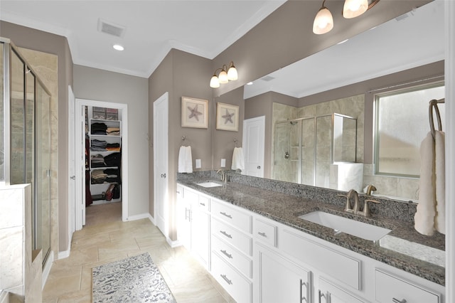 bathroom featuring vanity, a shower with shower door, and ornamental molding