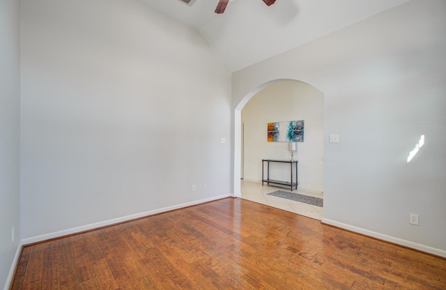 spare room featuring ceiling fan, light hardwood / wood-style floors, and lofted ceiling