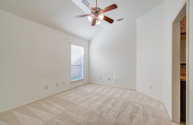 carpeted spare room featuring ceiling fan and lofted ceiling