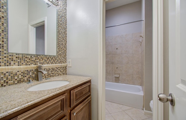 full bathroom featuring tiled shower / bath combo, tasteful backsplash, tile patterned flooring, toilet, and vanity