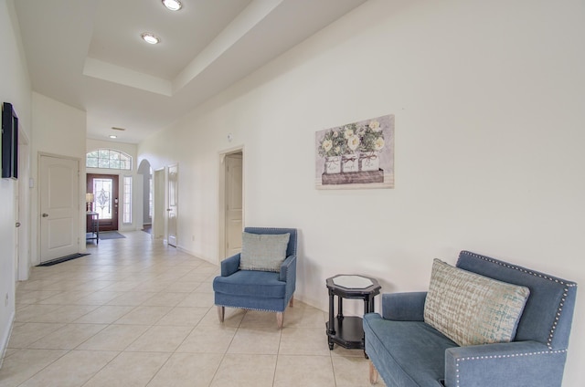 living area featuring light tile patterned floors and a raised ceiling