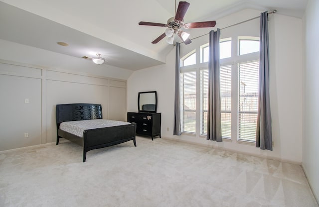 living area featuring light colored carpet, vaulted ceiling, and ceiling fan